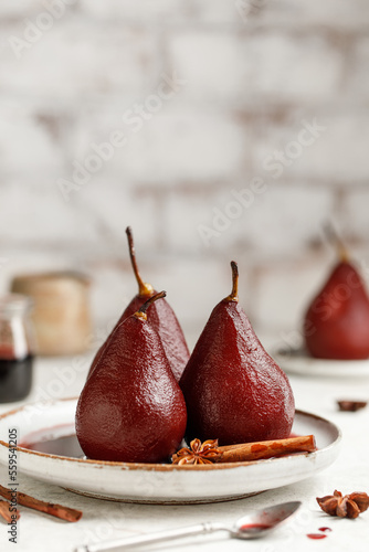 Pears in red wine on a plate with wine syrup and spices