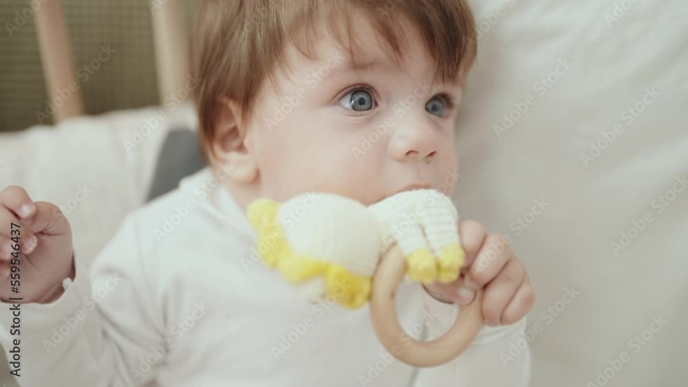 Adorable hispanic toddler sucking toy standing on cradle at bedroom Adorable hispanic toddler sucking toy standing on cradle at bedroom