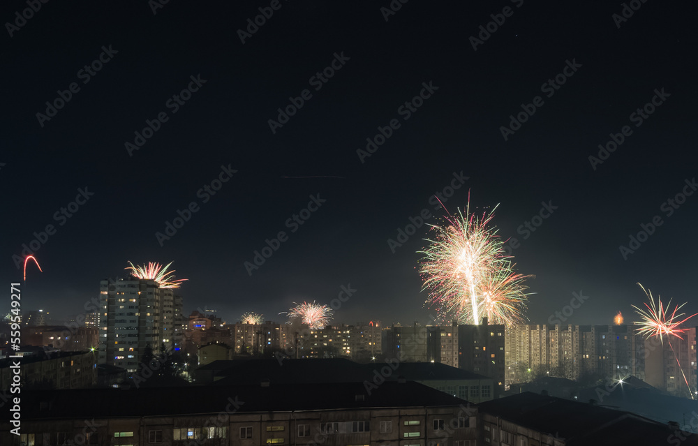 Bright colorful and multi-colored fireworks on New Year's Eve over the city, fireworks explode over a residential city