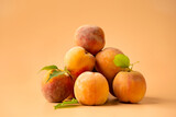 Fresh ripe juicy whole and cut red peaches on rough brown background.