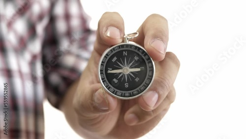 Hand holding the black compass on white background.