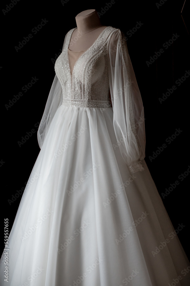 Classic satin wedding dress with sleeves on a mannequin Classic satin wedding dress with sleeves on a mannequin