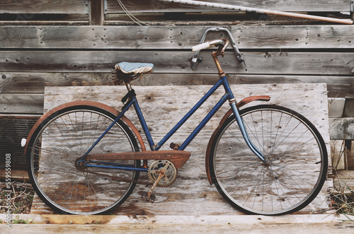 Old bicycle leaning on rustic wood and boards
