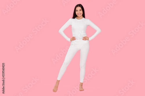 Woman in warm thermal underwear on pink background
