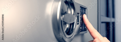 Woman opening steel safe with electronic lock, closeup. Banner design