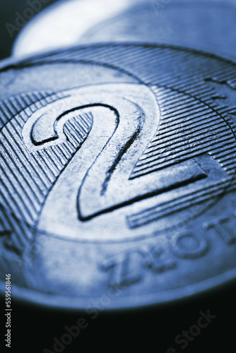 Translation: 2 zloty. Fragment of Polish two zloty coin closeup. National currency of Poland. Dark blue tinted vertical illustration for news about banking or finance. Money and banking. Macro © Deacon docs