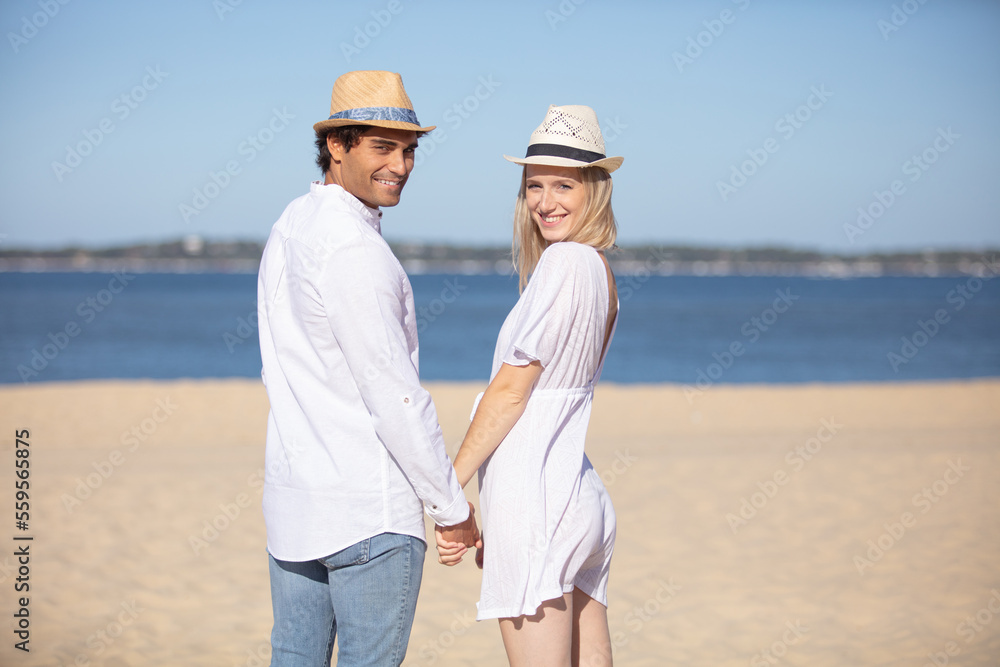 young couple holding hands on the beach young couple holding hands on the beach