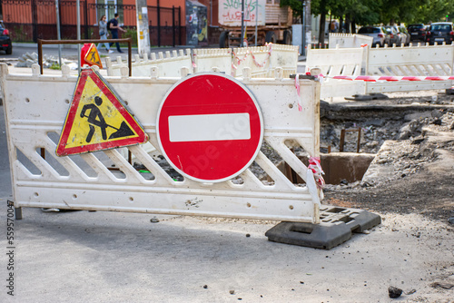 Repair of sewerage or water supply system with removed asphalt and dug hole on carriageway or road on acity street, which is limited by special anticipatory fences  photo