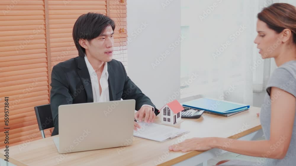 Young woman customer talking with agent about contract buying house and agreement of mortgage estate and explaining for planning in the home office, finance and investment, business concept. Young woman customer talking with agent about contract buying house and agreement of mortgage estate and explaining for planning in the home office, finance and investment, business concept.