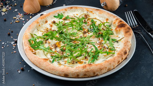 Italian pizza with pear slices, gorgonzola cheese, walnut and arugula.