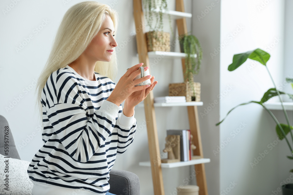 Beautiful woman with cup of drink in stylish room Beautiful woman with cup of drink in stylish room