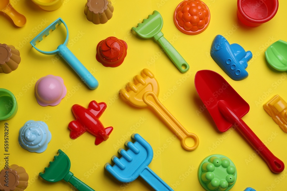 Beach sand toys on yellow background, flat lay Beach sand toys on yellow background, flat lay