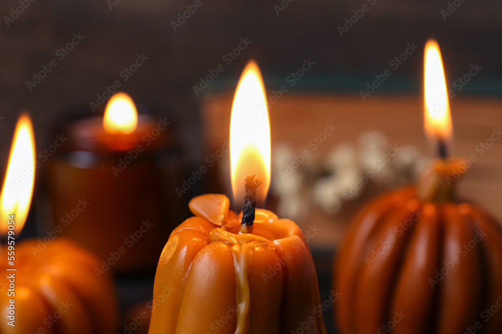Burning candles on blurred background, closeup. Autumn atmosphere Burning candles on blurred background, closeup. Autumn atmosphere
