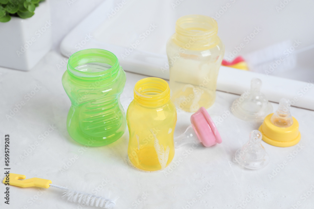 Baby bottles and nipples after washing on white countertop in kitchen, above view Baby bottles and nipples after washing on white countertop in kitchen, above view
