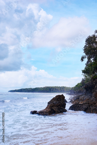 Beautiful tropiical landscape. Beach with sand, rocks and blue cloudy sky. photo