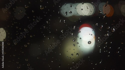 Moody rain on window during storm with bokeh traffic lights
