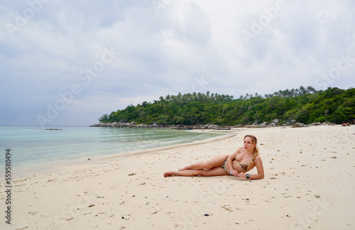 Vacation on the seashore. Young woman lying on the beautiful tropical beach.