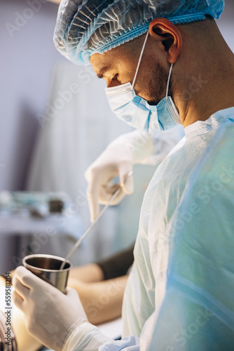 Surgeon doing operation at hospital using medical equipment photo