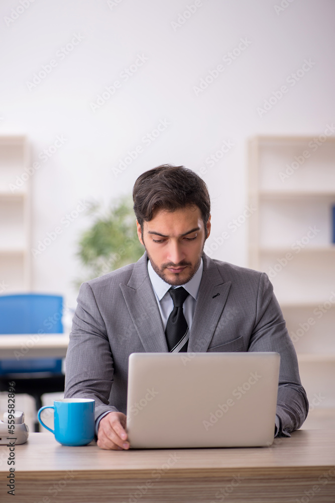 Young male employee and too much work in the office Young male employee and too much work in the office