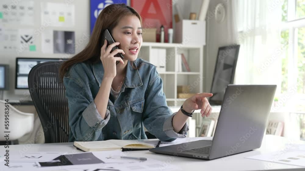 Asian Woman Graphic designer talking on mobile phone while working in office. Artist Creative Designer Illustrator Graphic Skill Concept. Asian Woman Graphic designer talking on mobile phone while working in office. Artist Creative Designer Illustrator Graphic Skill Concept.