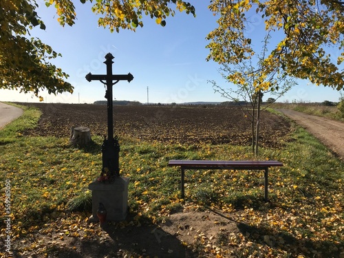 A Crucifix and a Bench at a Crossroad