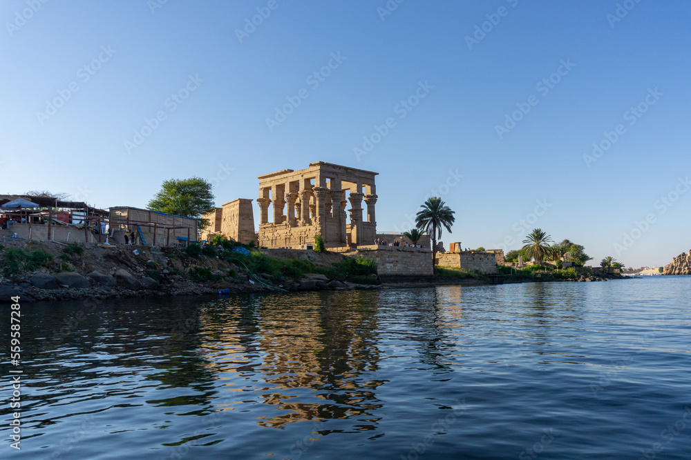 Small temple next to the Philae temple, seen from the Nile river on a sunny day.