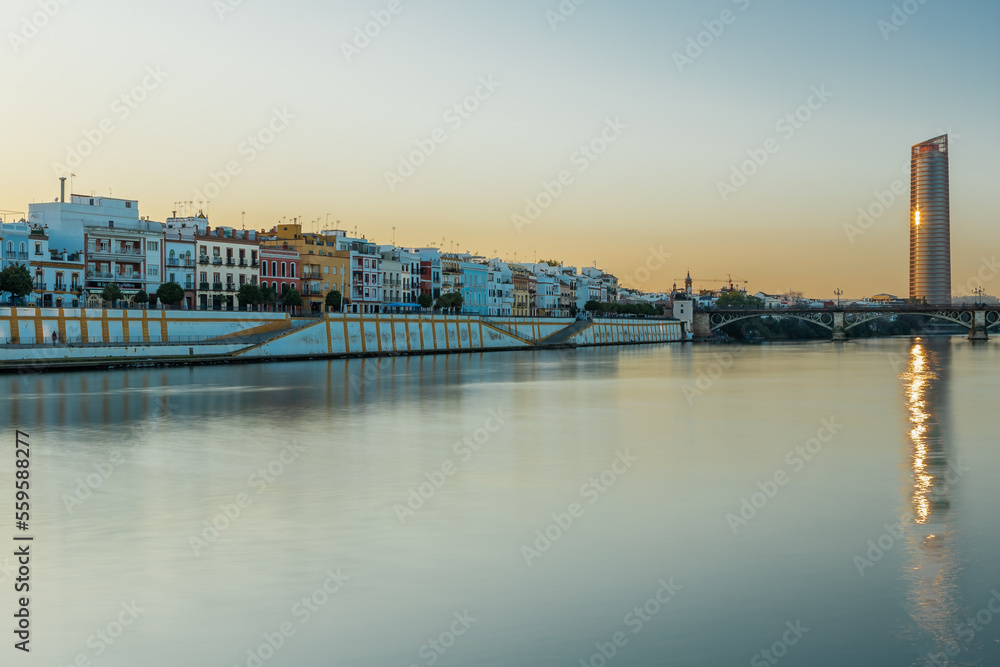 Sunset over the authentic neighborhood of Tirana in Seville with views on Calle Betis, Torre Sevilla and with awesome reflections in the river Guadalquivir, creating magic atmosphere and views