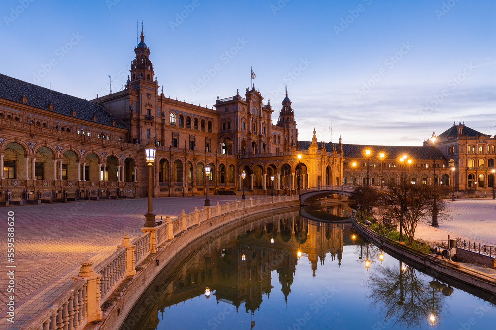 The beautiful decorated Plaza de España (English: Spanish Square) during an colourful sunrise is a touristic spot in a park in the centre of Seville, Spain, built in 1928 for the 1929 world exposition