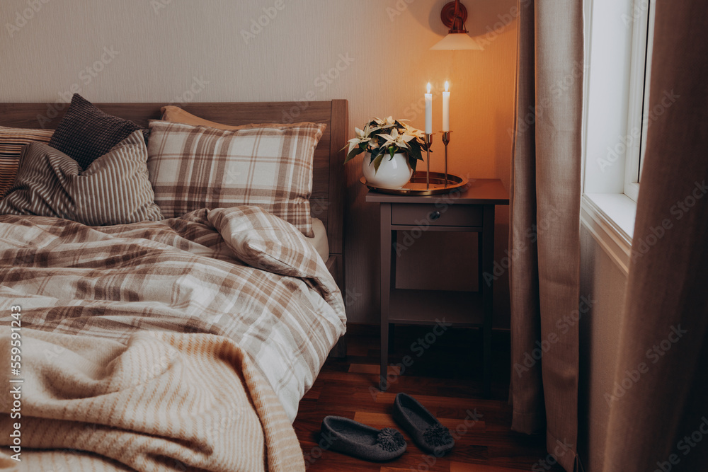 cozy scandinavian bedroom interior in natural tones, blanket candles houseplants