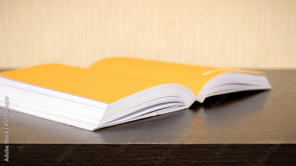 An open book lies diagonally on a dark wooden table An open book lies diagonally on a dark wooden table
