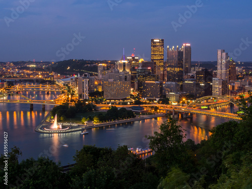 Downtown Pittsburgh skyline at night with rivers  bridges  and the fountain at Point State Park.