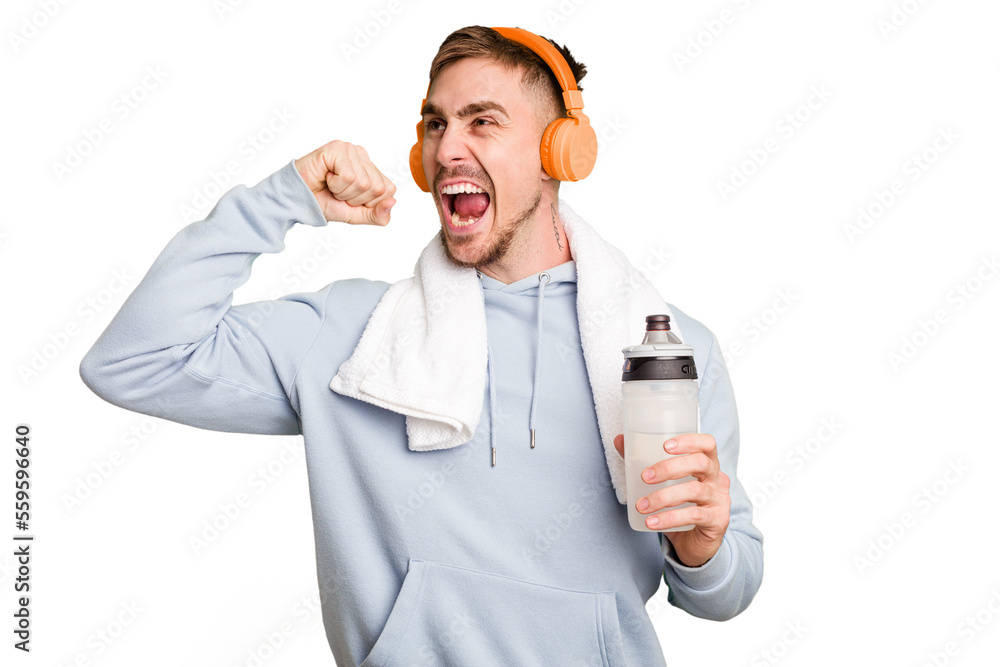 Φωτογραφία Young caucasian sporty man ready to start his gym day raising fist after a victory, winner concept