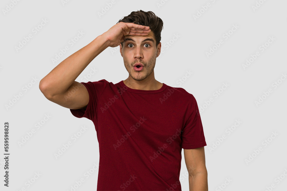 Young handsome caucasian man isolated on white background looking far away keeping hand on forehead. Young handsome caucasian man isolated on white background looking far away keeping hand on forehead.