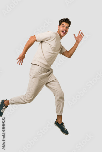 Young caucasian man jumping isolated on white background