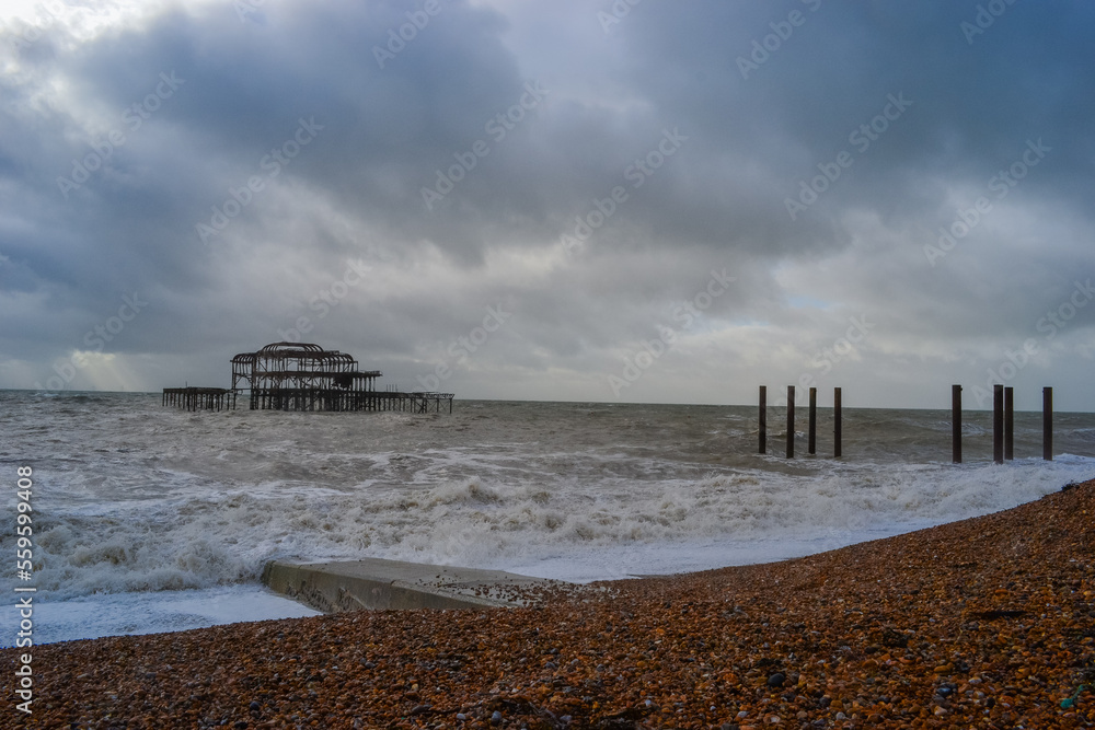 Burnt out Brighton Pier during a storm and sunset