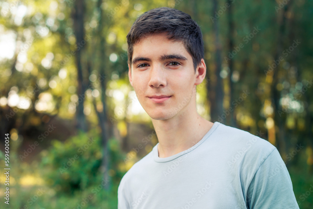 A young man with black hair smiling. Portrait of a gay in nature A young man with black hair smiling. Portrait of a gay in nature