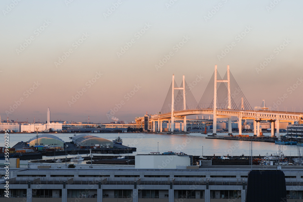 港の見える丘公園から見た夕焼けでオレンジに染まる横浜港とベイブリッジ