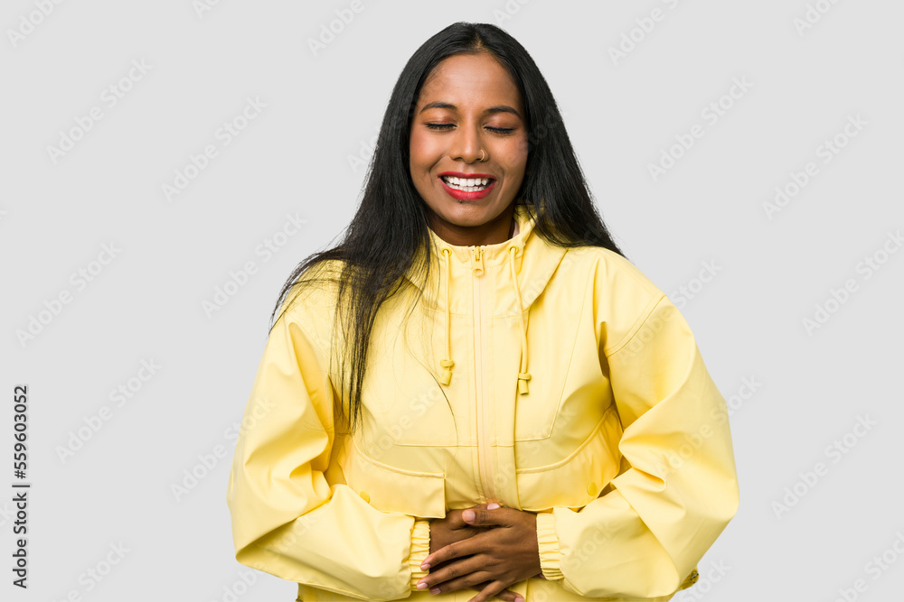 Young Indian woman cut out isolated on white background touches tummy, smiles gently, eating and satisfaction concept. Young Indian woman cut out isolated on white background touches tummy, smiles gently, eating and satisfaction concept.