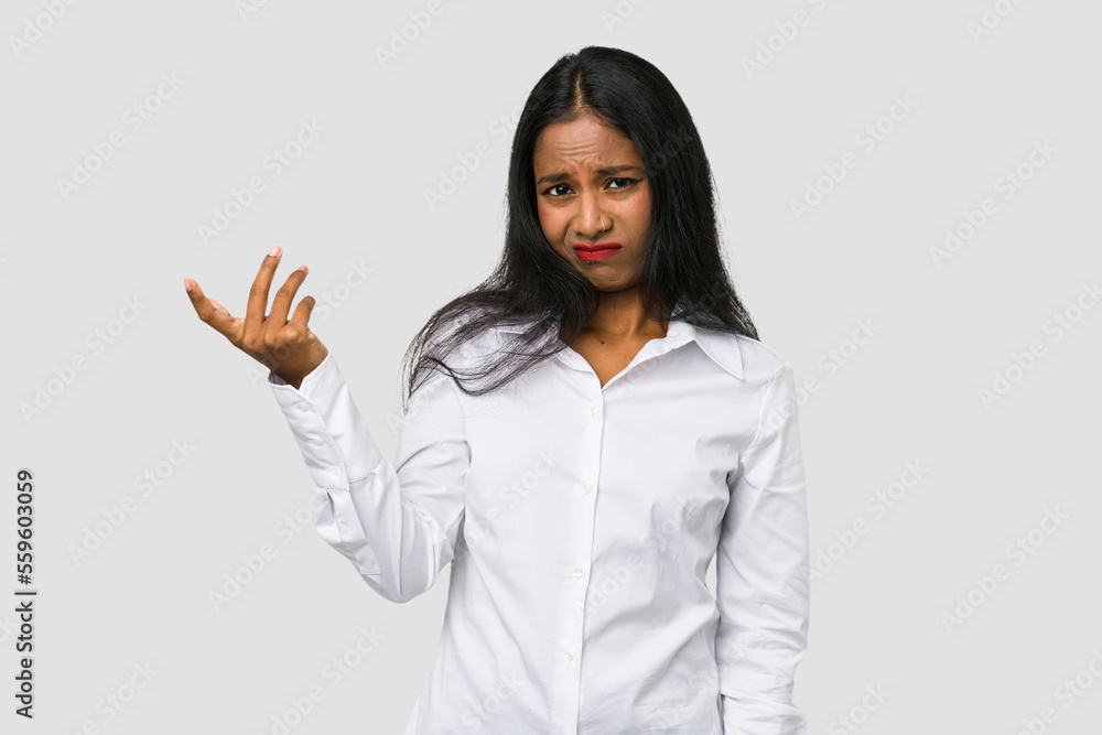 Young Indian woman cut out isolated on white background doubting and shrugging shoulders in questioning gesture. Young Indian woman cut out isolated on white background doubting and shrugging shoulders in questioning gesture.