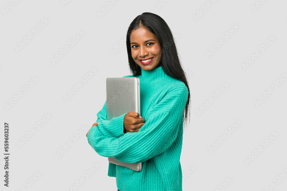 Young indian woman holding a laptop isolated on white background Young indian woman holding a laptop isolated on white background