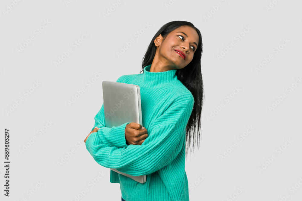 Young indian woman holding a laptop isolated on white background Young indian woman holding a laptop isolated on white background