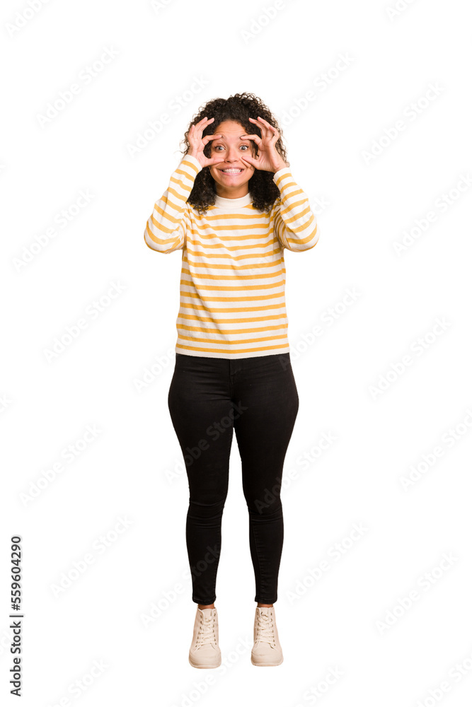 Young african american woman with curly hair cut out isolated keeping eyes opened to find a success opportunity. Young african american woman with curly hair cut out isolated keeping eyes opened to find a success opportunity.