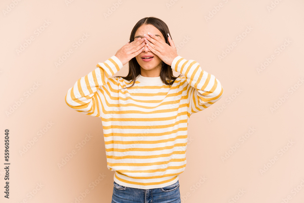 Young colombian woman isolated on beige background afraid covering eyes with hands. Young colombian woman isolated on beige background afraid covering eyes with hands.