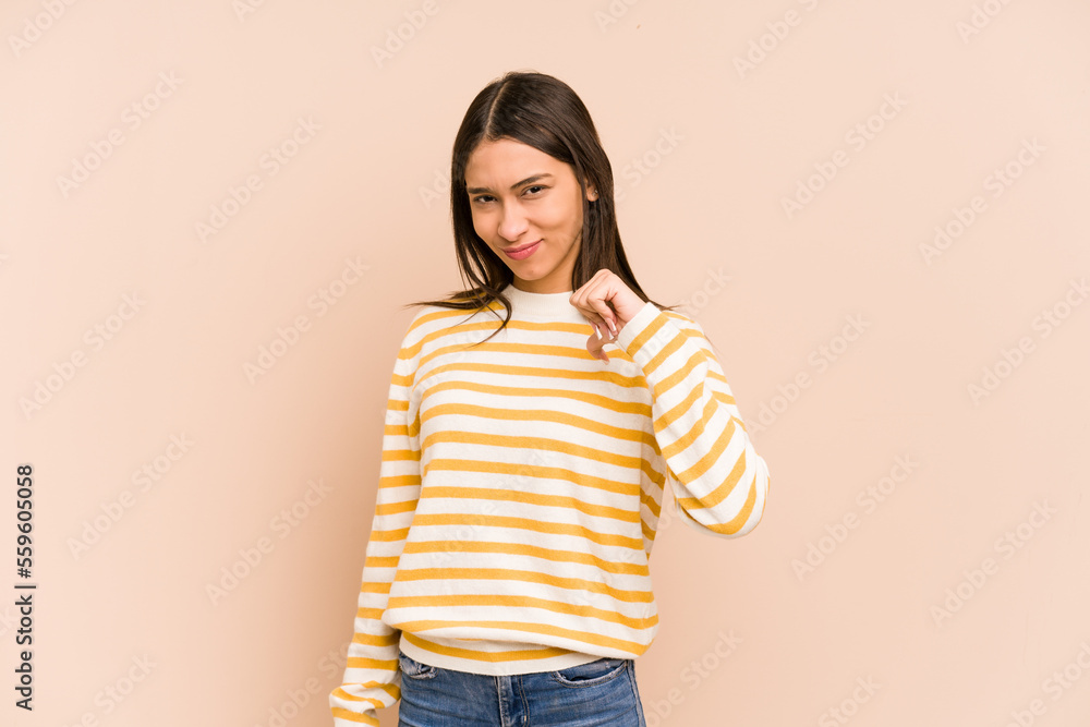 Young colombian woman isolated on beige background showing thumb down, disappointment concept. Young colombian woman isolated on beige background showing thumb down, disappointment concept.