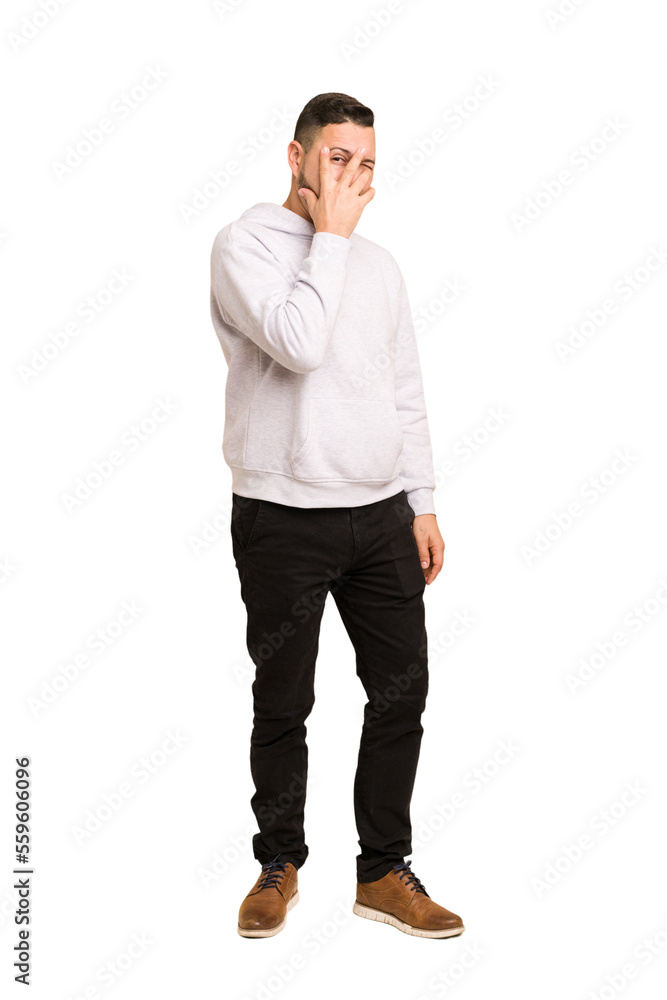 Full body adult latin man cut out isolated blink at the camera through fingers, embarrassed covering face. Full body adult latin man cut out isolated blink at the camera through fingers, embarrassed covering face.