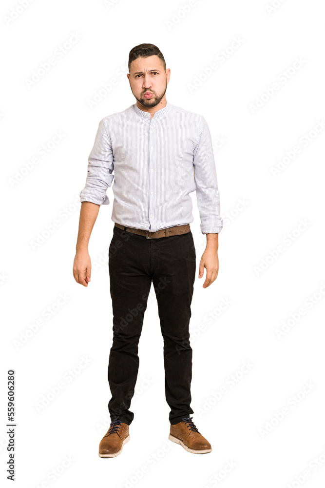 Full body adult latin man cut out isolated blows cheeks, has tired expression. Facial expression concept. Full body adult latin man cut out isolated blows cheeks, has tired expression. Facial expression concept.