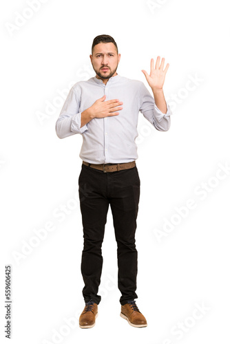 Full body adult latin man cut out isolated taking an oath, putting hand on chest.