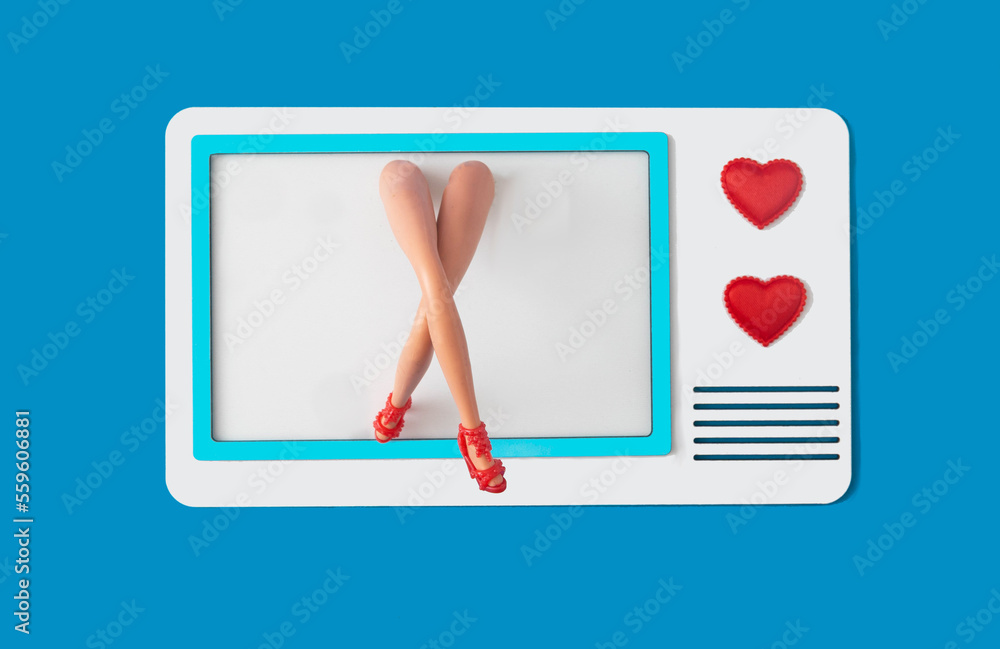 Women's legs with red high heels shoes coming out of a retro old blue and white tv against white background. Design for Valentine movies advertisement. Surreal concept for romance thematic banner
