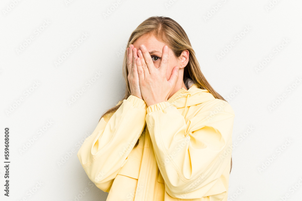 Young caucasian woman isolated on white background blink through fingers frightened and nervous. Young caucasian woman isolated on white background blink through fingers frightened and nervous.