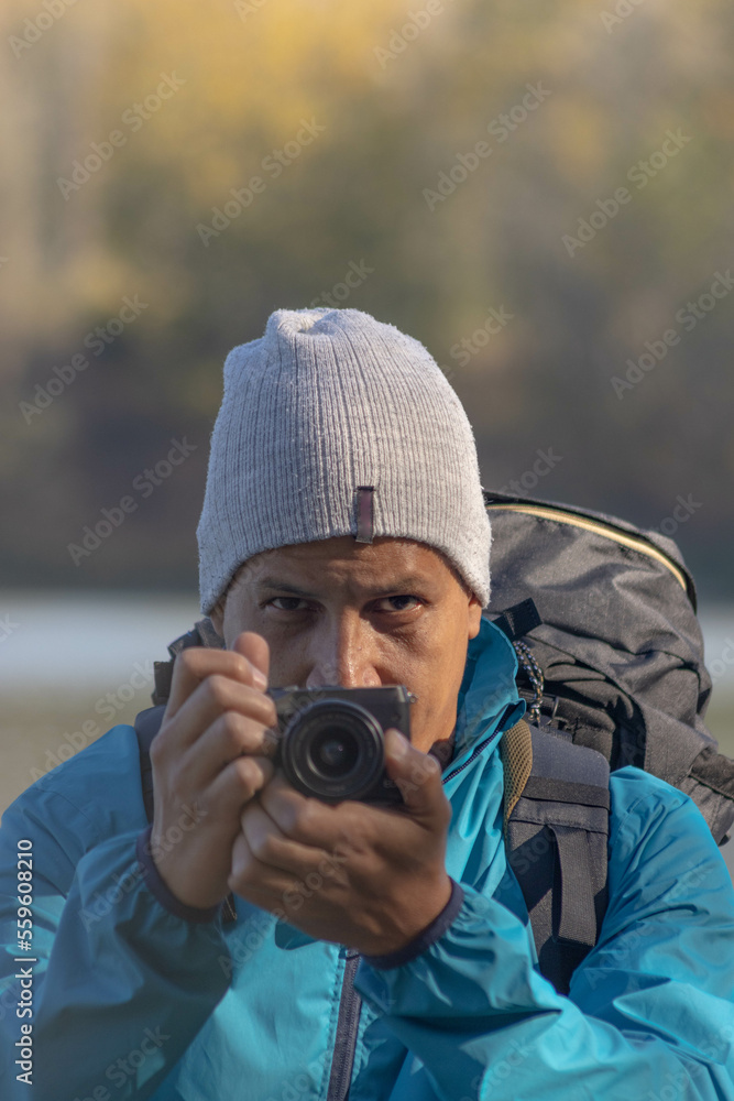 Portrait of traveler man at lake in autumn taking a photo with the digital camera Portrait of traveler man at lake in autumn taking a photo with the digital camera